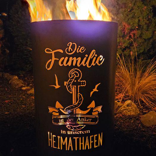 Brennende Feuertonne „Familie – Heimathafen“ mit leuchtendem Anker-Motiv und Flammenspiel im Garten