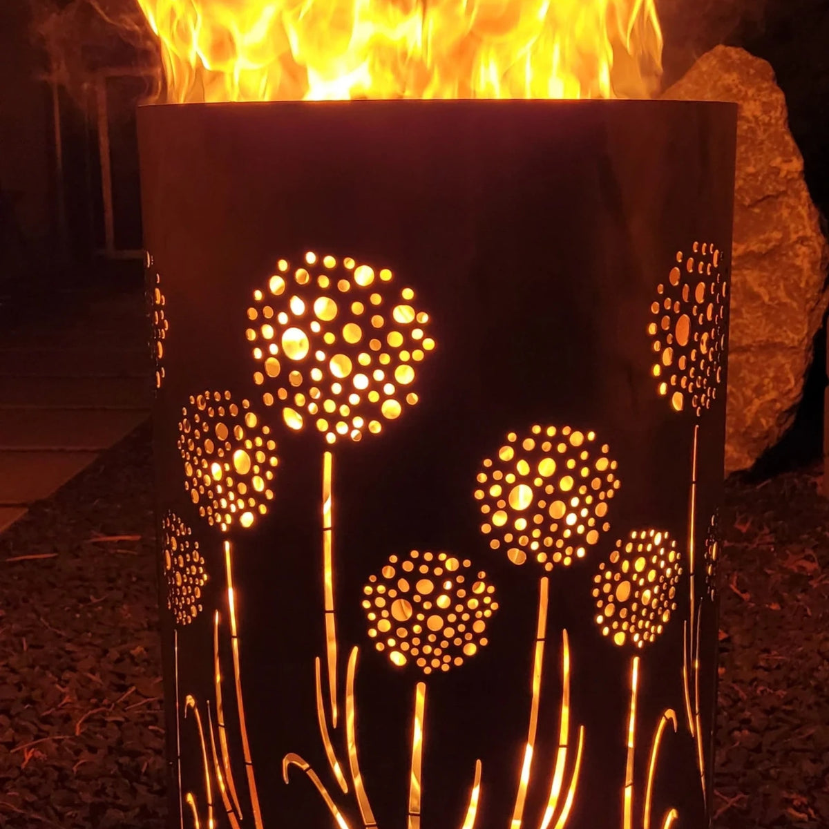 Brennende Feuertonne „Pusteblume“ mit leuchtendem Blumenmotiv und intensivem Flammenspiel – dekorative Feuerstelle für Garten und Terrasse