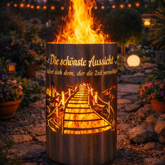 Motiv-Feuertonne „Die schönste Aussicht“ mit leuchtendem Steg-Motiv und Flammen in einem stimmungsvoll beleuchteten Garten.